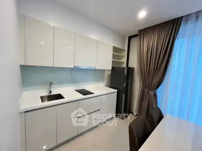 Modern kitchen with sleek white cabinets and stainless steel appliances