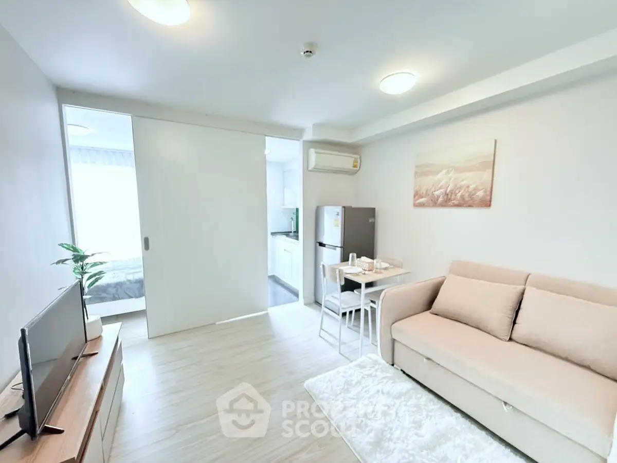 Modern living room with cozy sofa and dining area, open layout to kitchen, bright and inviting space.