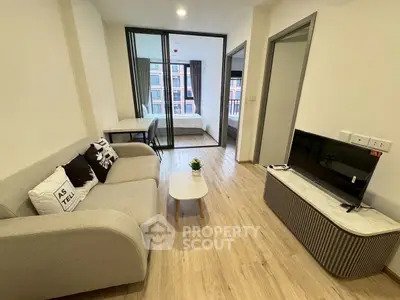 Modern living room with stylish furniture and view into bedroom, perfect for urban living.