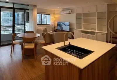 Spacious open-plan living room with modern kitchen and city view balcony.