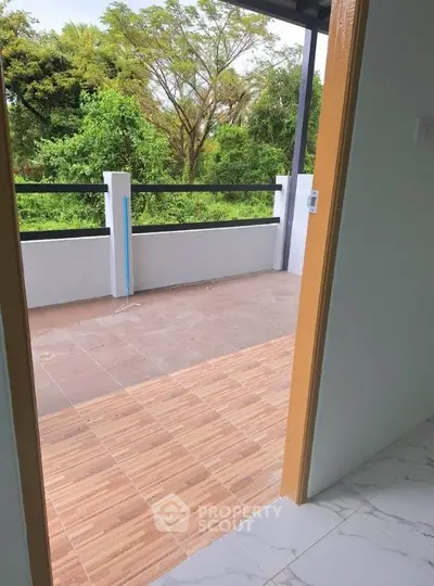 Spacious balcony with scenic green view, perfect for relaxation and outdoor enjoyment.