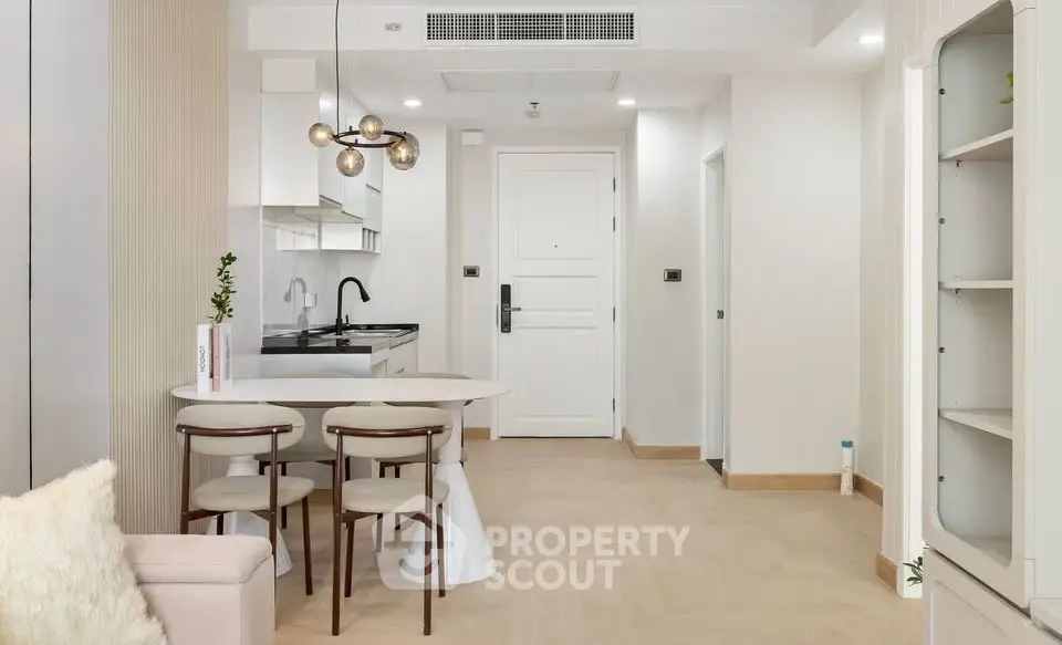 Modern open-layout kitchen and dining area with stylish lighting and minimalist design.