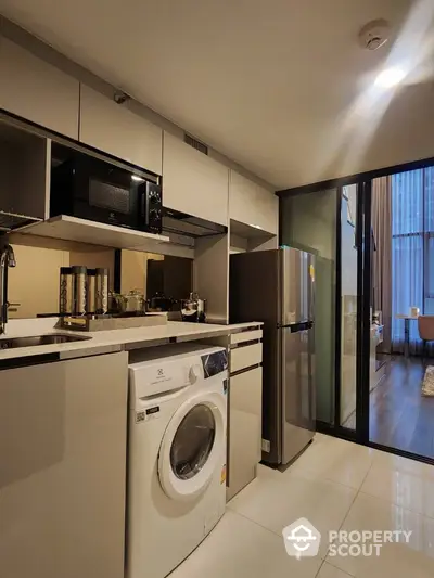 Modern kitchen with sleek appliances and washing machine in stylish apartment