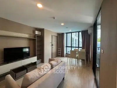 Spacious modern living room with large windows and dining area in a stylish apartment.