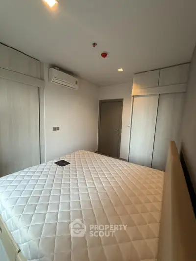 Modern bedroom with built-in wardrobes and air conditioning unit