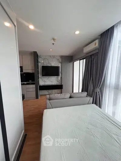 Modern living room with open kitchen and stylish decor in a high-rise apartment.