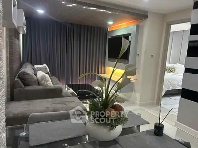 Modern living room with cozy seating and elegant decor adjacent to a stylish bedroom.