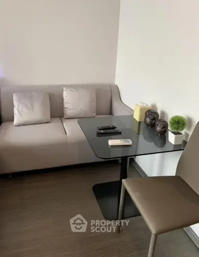 Modern living room with sleek sofa and glass table, perfect for urban living.