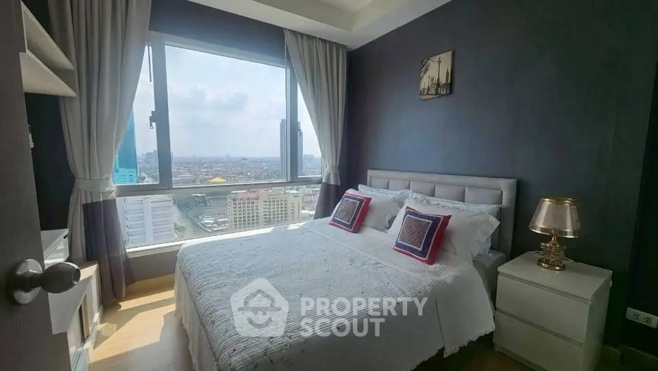Cozy bedroom with stunning city view, featuring elegant decor and ample natural light.