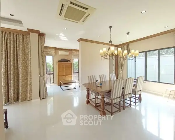 Spacious dining room with elegant chandelier and large windows