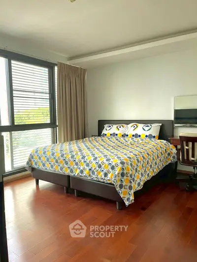 Cozy bedroom with modern decor and large window for natural light