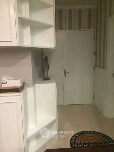 Modern apartment entrance with stylish shelving and neutral decor