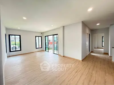 Spacious modern living room with large windows and wooden flooring