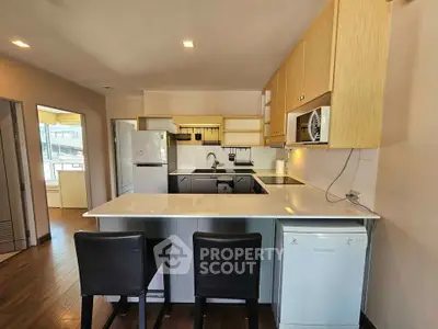 Modern kitchen with sleek countertops and built-in appliances in a stylish apartment.
