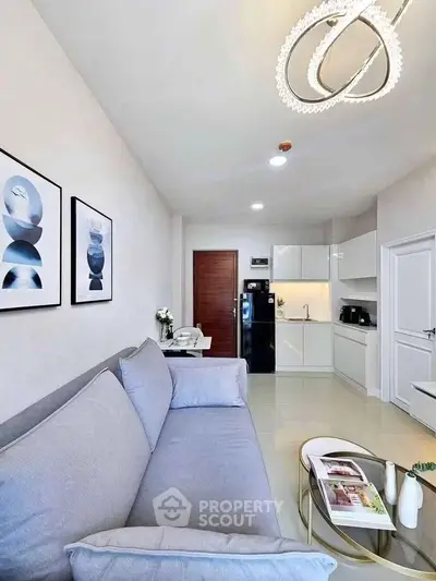 Modern living room with sleek kitchen, stylish decor, and elegant lighting in a contemporary apartment.