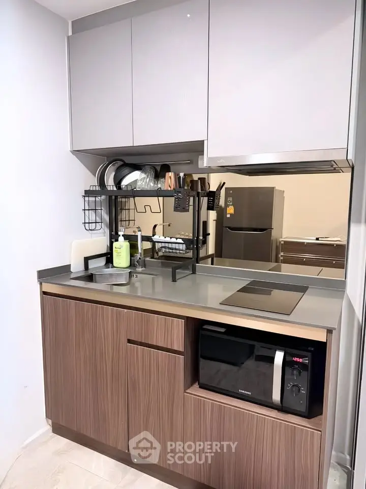 Modern compact kitchen with sleek cabinetry and built-in appliances, perfect for urban living.