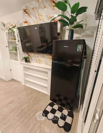 Stylish living room with modern decor, flat-screen TV, and sleek black refrigerator.