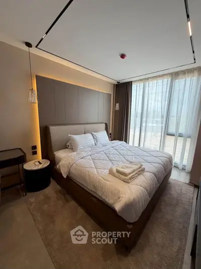 Luxurious bedroom with modern decor and large window offering natural light.