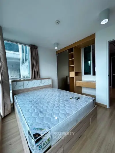 Modern bedroom with large window and built-in wooden storage