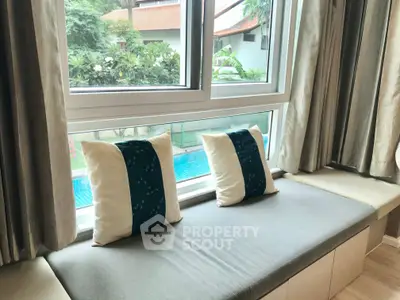 Charming window seat with pool view in a serene residential setting, perfect for relaxation and enjoying nature.