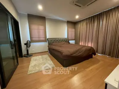 Spacious bedroom with modern decor and large windows in a stylish apartment.