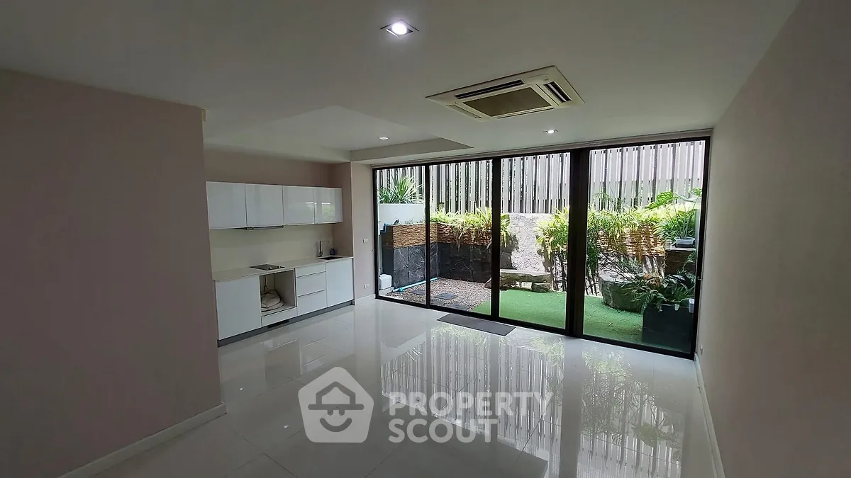 Spacious modern living room with garden view and sleek kitchen