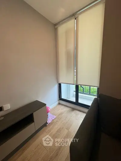 Cozy small living room with modern furniture and large window for natural light.