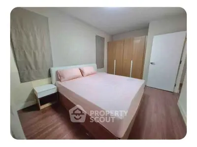 Cozy bedroom with wooden flooring and modern wardrobe, perfect for restful nights.
