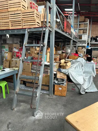 Industrial storage space with metal ladder and stacked boxes, ideal for warehouse needs.