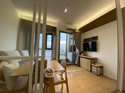 Modern living room with balcony view, stylish furniture, and natural lighting in a cozy apartment.