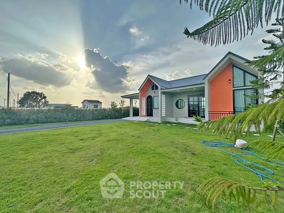 Charming modern house with lush green lawn and stunning sunset view.