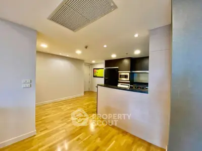 Modern open kitchen with sleek appliances and wooden flooring in a stylish apartment