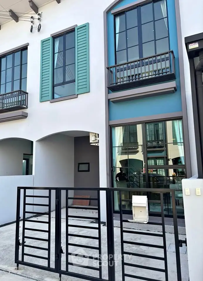 Modern townhouse exterior with stylish windows and gated entrance in a vibrant neighborhood.