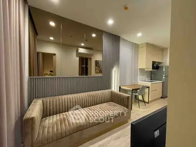 Modern living room with stylish sofa and open kitchen layout in a contemporary apartment.