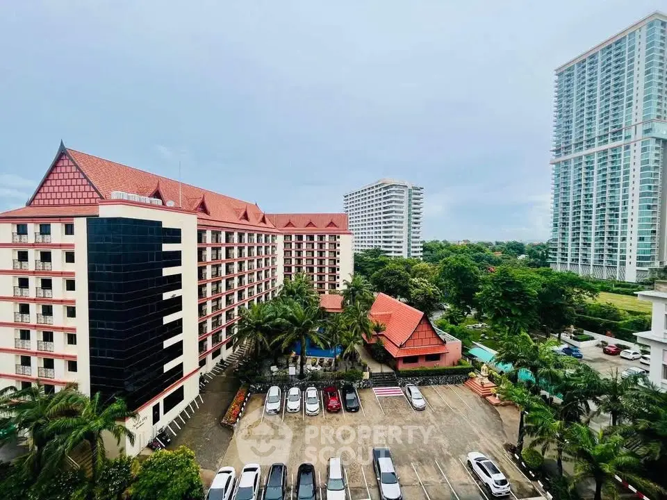Stunning aerial view of modern residential complex with ample parking and lush greenery.