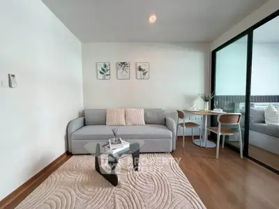 Modern living room with stylish decor and cozy ambiance, featuring a sleek sofa and elegant glass coffee table.