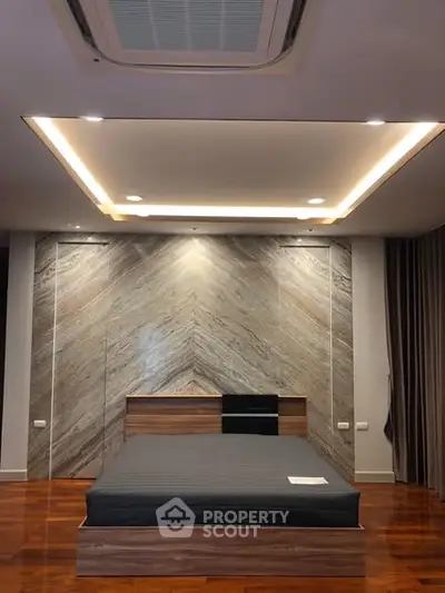 Luxurious modern bedroom with elegant wood flooring and stylish ceiling lights.