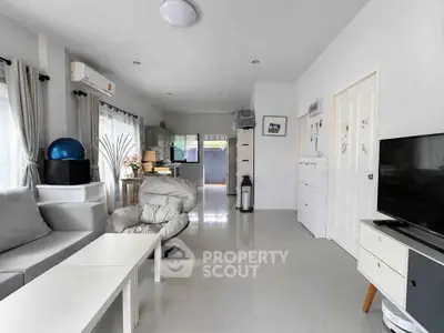 Modern living room with sleek furniture and open layout, featuring a cozy seating area and bright natural light.
