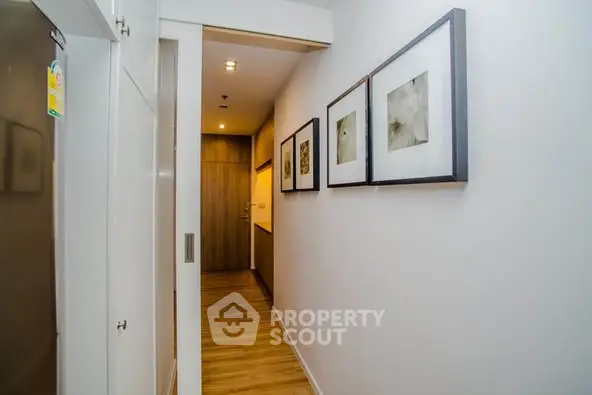 Modern hallway with wooden flooring and framed art on walls
