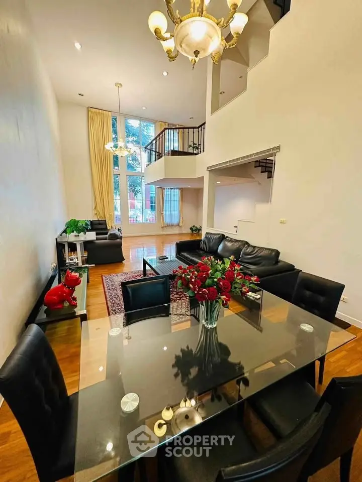Elegant living room with high ceilings, modern chandelier, and stylish furniture in a spacious open layout.
