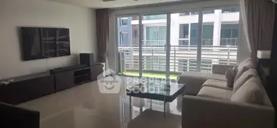 Spacious modern living room with large windows and sleek furniture in a luxury apartment.