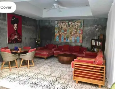 Stylish living room with red sofas, artistic decor, and patterned tile flooring.
