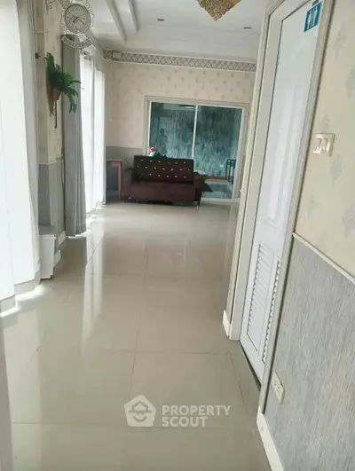 Spacious hallway leading to a cozy living area with elegant decor and natural light.