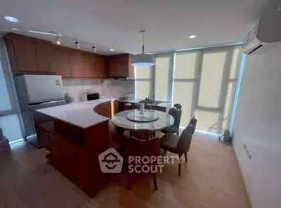 Modern kitchen with sleek design, featuring a round dining table and large windows for natural light.