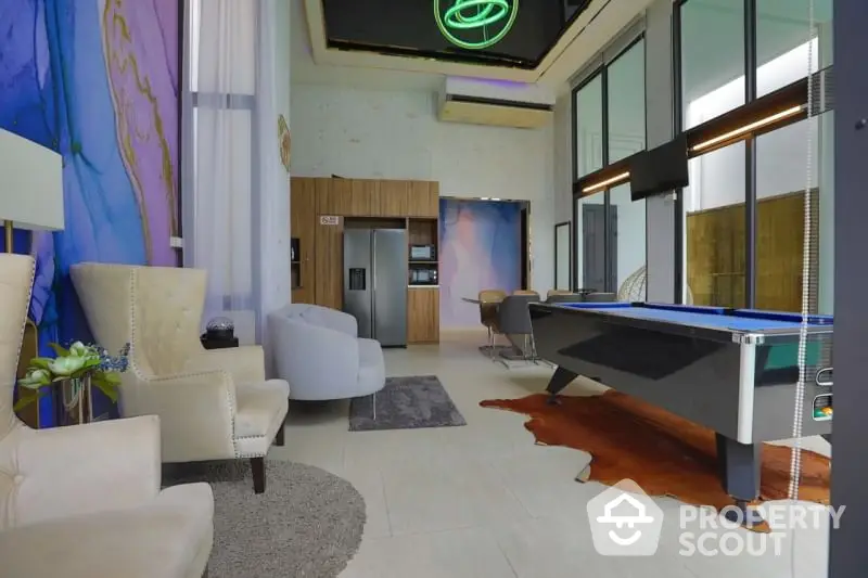 Spacious modern living room with stylish furniture, pool table, and vibrant neon lighting, perfect for entertaining and relaxation.