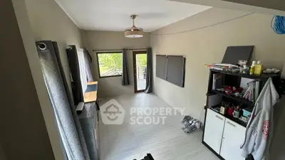 Spacious room with large windows and modern decor, perfect for versatile living space.