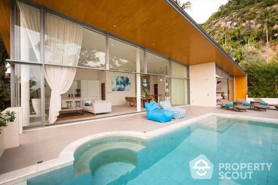 Luxurious modern villa with expansive glass walls and private pool in tropical setting