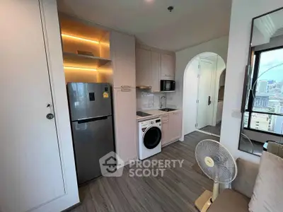 Modern compact kitchen with integrated appliances and city view, perfect for urban living.