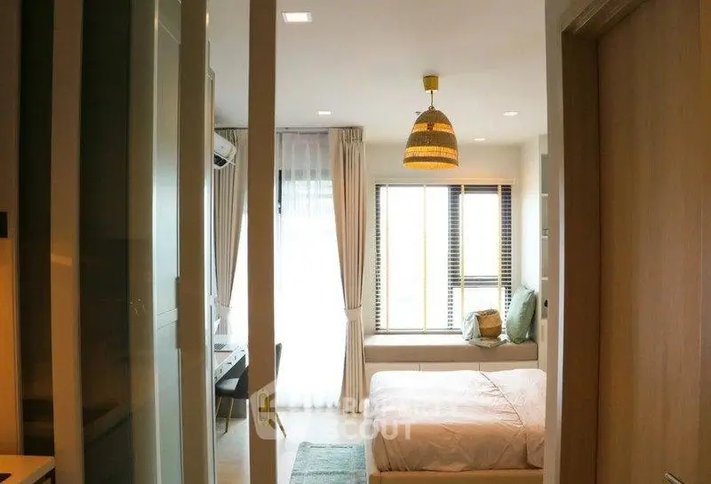 Cozy bedroom with natural light and modern decor in a stylish apartment.