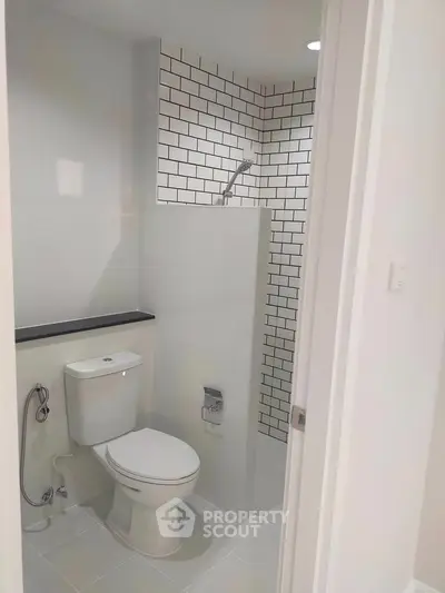 Modern bathroom with sleek white tiles and shower area